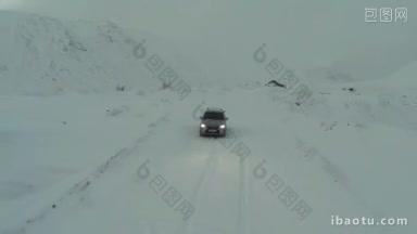 鸟瞰银色汽车行驶在积雪覆盖的山路上